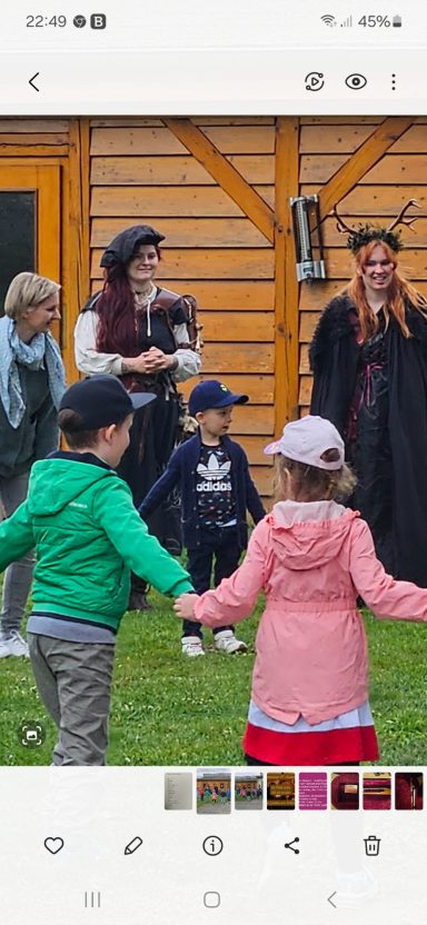 Gruppe von Menschen, darunter Kinder, die im Freien zusammen spielen und lachen.