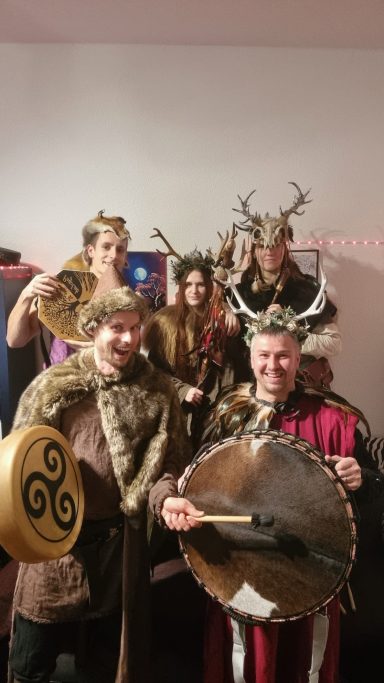 Gruppenszene von Personen in historischen Kostümen mit Shields und Requisiten.